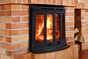 brick wood fireplace insert using red and brown brick and a black metal frame