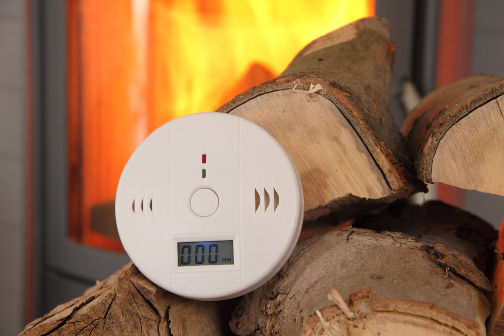 smoke alarm in front of a fireplace for fire prevention safety for homes for national fire safety month